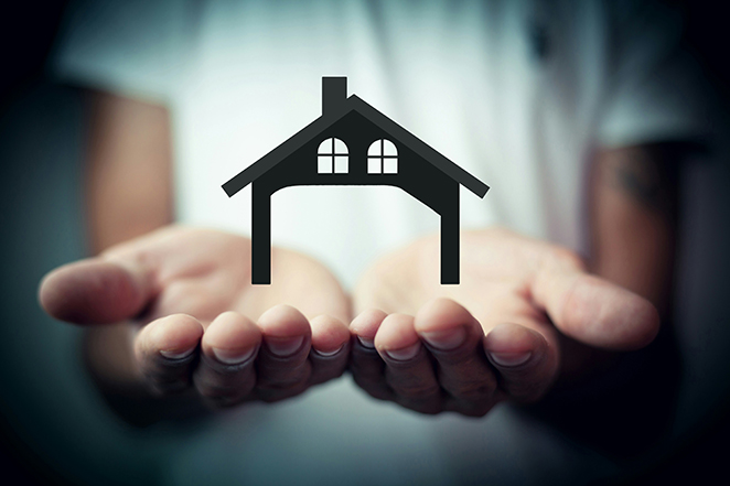 Hands holding a small house icon, representing home affordability